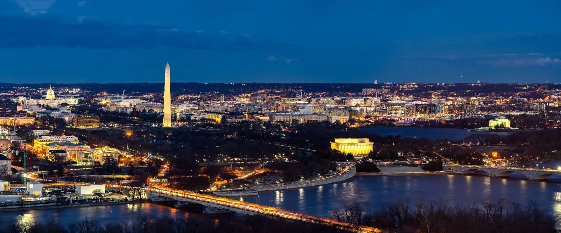 Vista noturna de Washington D.C., com o Washington Monument e o Capitólio iluminados